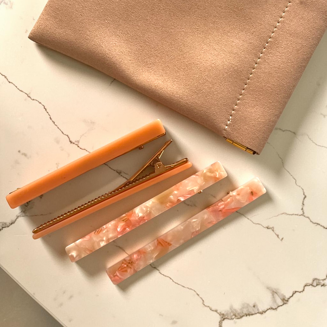 Slim peach acetate barrette set styled with a blush notebook